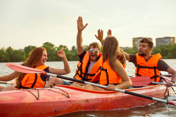 istock Happy friends kayaking on river with sunset on the background 1179601451