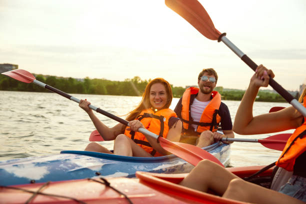 istock Happy friends kayaking on river with sunset on the background 1179601473