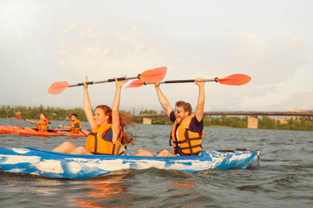 istock Happy friends kayaking on river with sunset on the background 1179601552