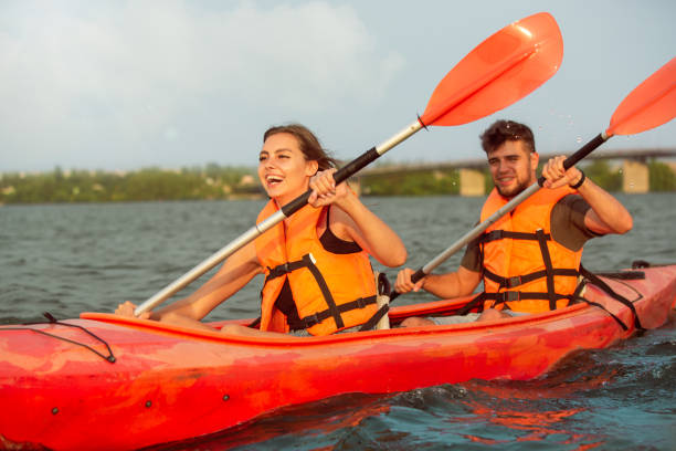 istock Happy couple kayaking on river with sunset on the background 1179601591