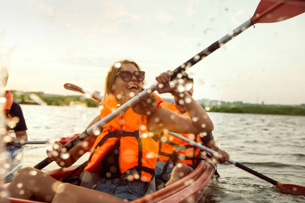 istock Happy friends kayaking on river with sunset on the background 1179601649