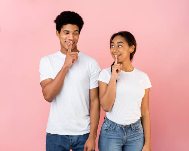 istock Amazed teen couple make silence sign, keep forefingers on lips 1179602332