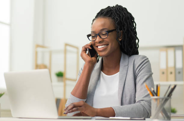 istock Black Young Lady Having Phone Conversation Sitting At Workplace 1179602873