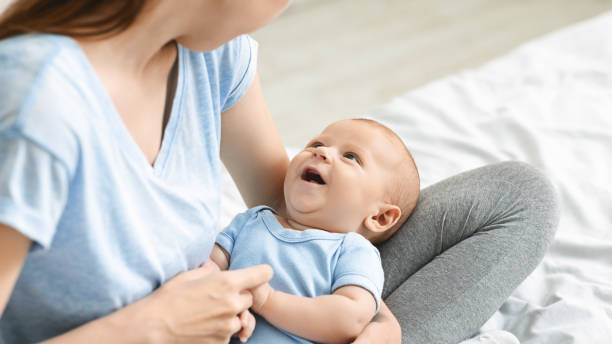 istock Adorable baby boy looking at mom, lying on her laps 1179602940