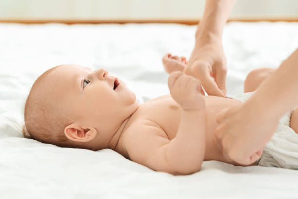istock Mother fixing diaper on her adorable infant son 1179603077