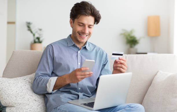 istock Guy Using Phone, Credit Card And Laptop Providing Payment Indoor 1179604041