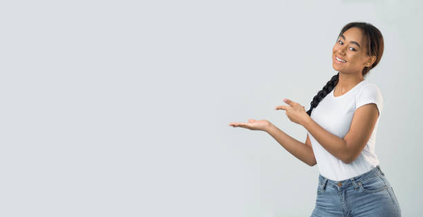 istock Pretty girl holding copy space on palm and pointing on it 1179604931