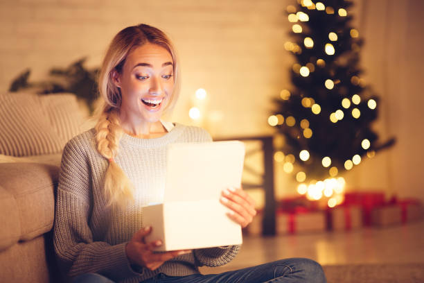mujer sorprendida abrir caja de regalo de navidad mágica - beautiful women gift christmas fotografías e imágenes de stock