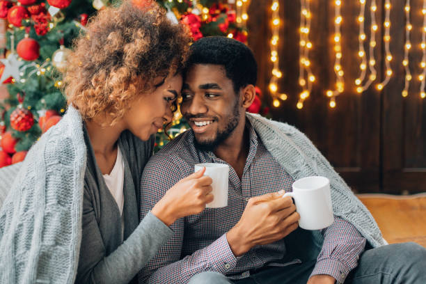 istock Young couple drinking coffee at Christmas tree 1179605627