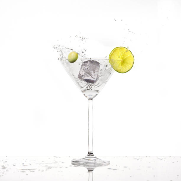 Splash from olive in a glass of cocktail, isolated on the white background stock photo
