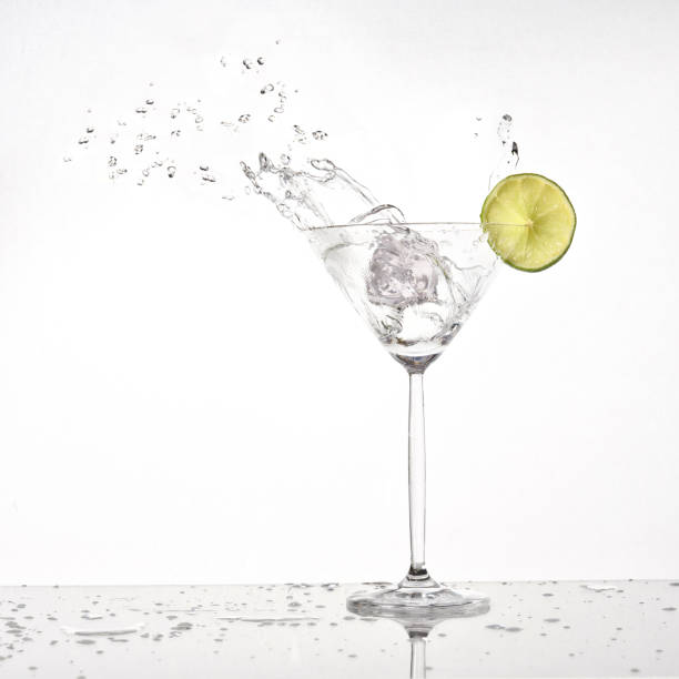 Splash from olive in a glass of cocktail, isolated on the white background stock photo