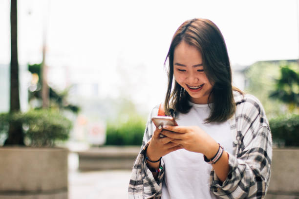 istock Young Asian Corporate Female Texting Customer Client on Smartphone 1179607892