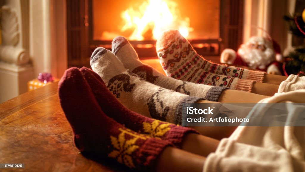 Nahaufnahme Foto von Familienfüßen in Wollsocken, die neben dem Kamin liegen - Lizenzfrei Weihnachten Stock-Foto
