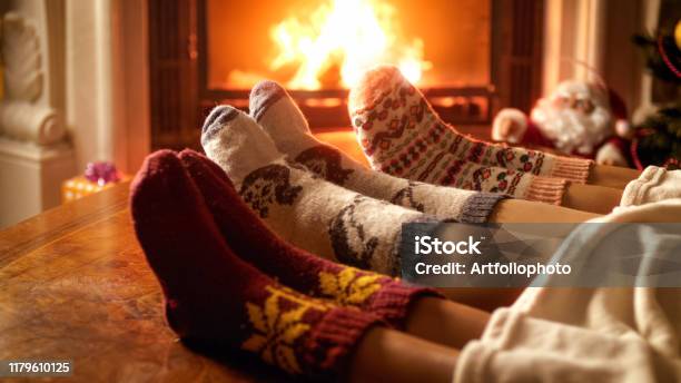 Closeup Foto Van Familie Voeten In Wollen Sokken Liggend Naast Open Haard Stockfoto en meer beelden van Kerstmis