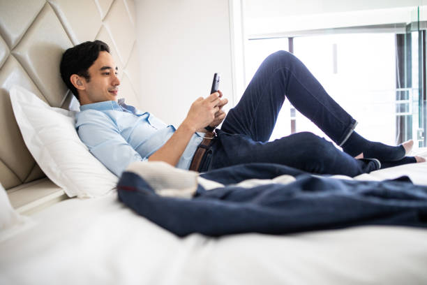 istock Businessman text messaging from hotel room 1179613326