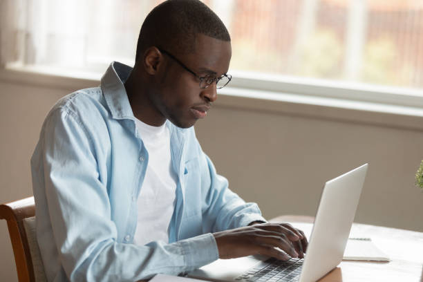 istock Serious concentrated young african american man working remotely with computer. 1179614167