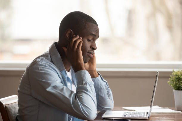 istock Overwhelmed exhausted young african american guy suffering from headache. 1179614172