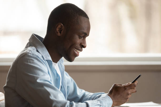 istock Smiling african ethnicity guy using mobile app, shopping. 1179614180