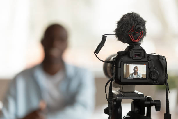 istock Close up professional camera filming young smiling african american speaker. 1179614183