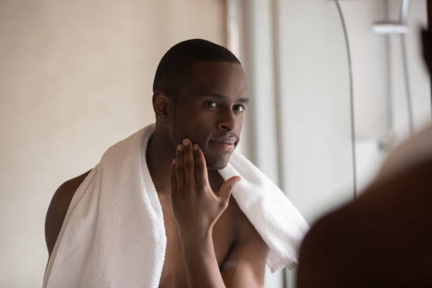 istock Confident african american young man looking in mirror after shower. 1179614260
