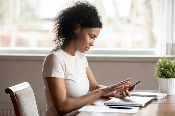 istock Calm african ethnic millennial woman using mobile apps on cellphone. 1179614267