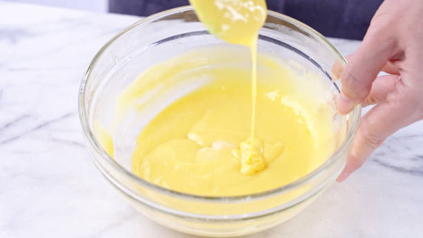 istock Mixing egg yolk into cake batter with green rubber spatula mixer tool stirring until smooth and blend well in a glass bowl. 1179617454