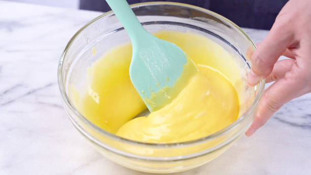 istock Mixing egg yolk into cake batter with green rubber spatula mixer tool stirring until smooth and blend well in a glass bowl. 1179617456