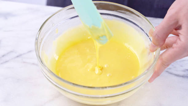 istock Mixing egg yolk into cake batter with green rubber spatula mixer tool stirring until smooth and blend well in a glass bowl. 1179617523