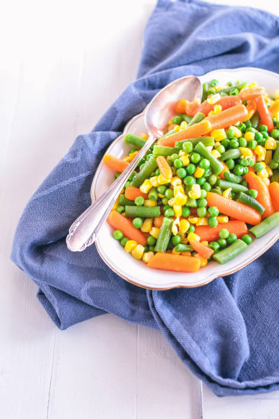 istock Peas, carrots, green beans and corn lie in a white bowl 1179617623
