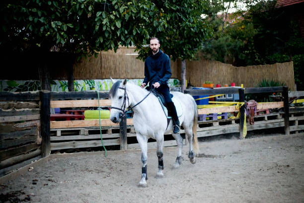 istock Young and attractive man riding brown horse 1179617687