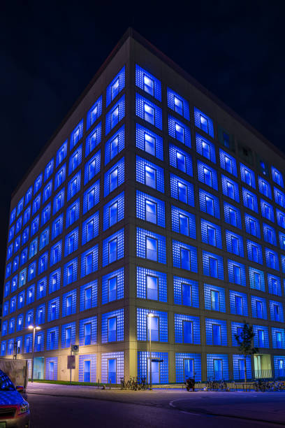 Germany, Illuminated blue facade of public library building skyscraper in downtown stuttgart city by night