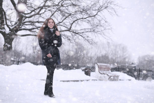 istock Girl in a winter park in snowfall 1179621381