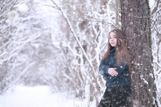 istock Girl in a winter park in snowfall 1179621518