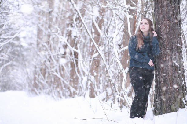 istock Girl in a winter park in snowfall 1179621532