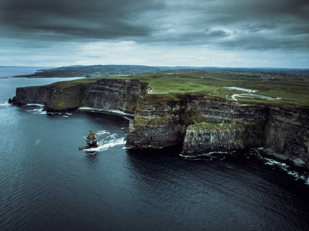 Areal view towards the beautiful and famous Cliffs of Moher under windy dramatic skyscape. Burren Region, County Clare, Ireland
