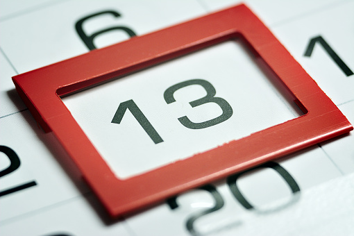 the thirteenth day of the month highlighted on the calendar with a red frame close-up macro, the mark on the calendar, the thirteenth date