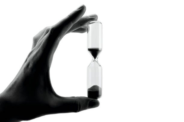 sablier isolé sur le fond blanc - sand clock human hand hourglass photos et images de collection