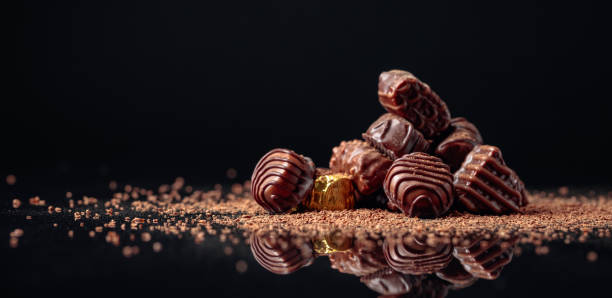 istock Chocolate candies on a black background sprinkled with chocolate chips. 1179630551
