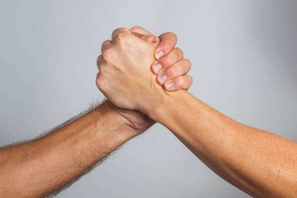 istock People are shaking hands. Friendly handshake, friends greeting, teamwork, friendship 1179630632