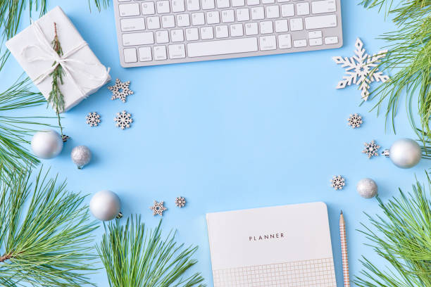 istock Flat lay christmas home office desk with pine branches and keyboard, christmas decorations on a blue background 1179631552