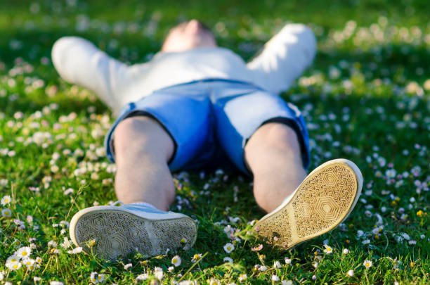 молодой подросток, лежащий на лугу - healthy lifestyle nature sports shoe childhood стоковые фото и изображения