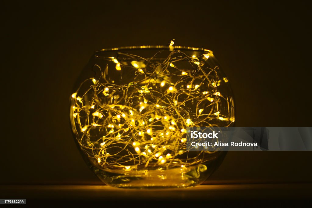 Christmas composition with Glass bowl light chain. Glass bowl with Christmas light chain. Led fairy lights with warm light. Decor for the home. Nightlight. Selective focus. Drinking Glass Stock Photo