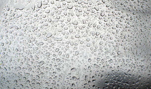 fondo brillante y metálico, cubierto de gotas de agua. textura del agua sobre una superficie metálica. - transparent puzzle glass jigsaw puzzle fotografías e imágenes de stock