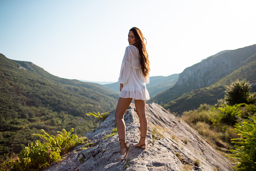 Beautiful woman in dress relaxing at mountain