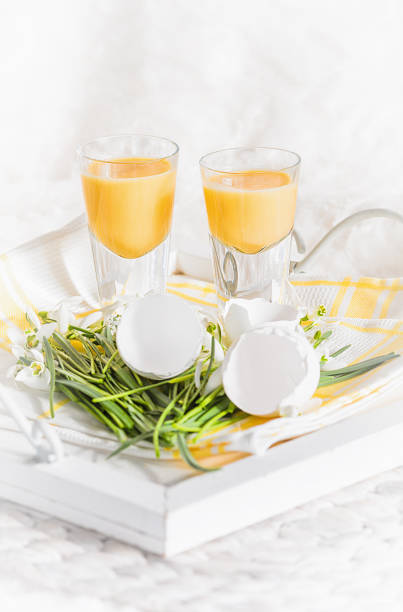 licor de huevo con cáscaras de huevo en una bandeja blanca - liqueur glass fotografías e imágenes de stock