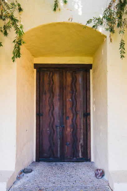 istock A rustic wooden door set deep in a stucco covered adobe wall plastered in a cream color 1179634401