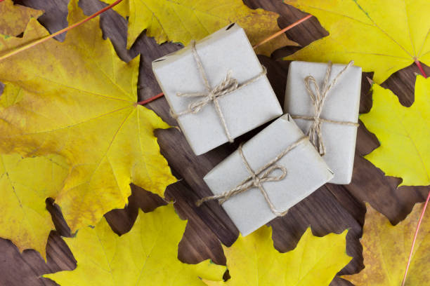 istock gift boxes among autumn leaves on a wooden surface 1179635138