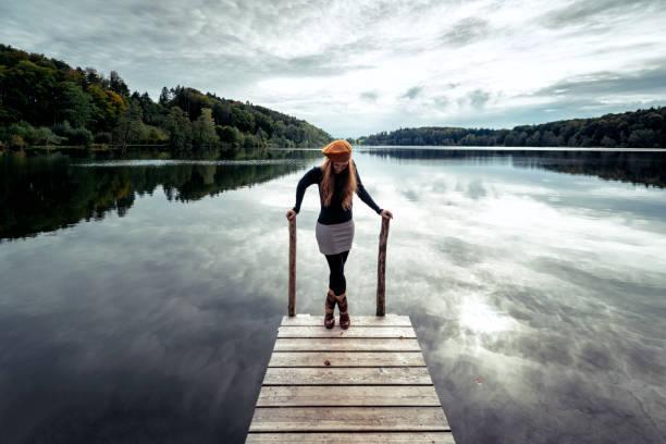 istock woman at a dock at a beautiful lake in austria 1179636200