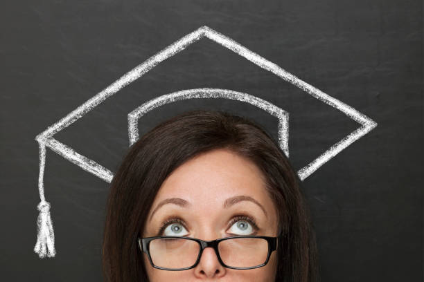 Woman and graduation hat over head on blackboard