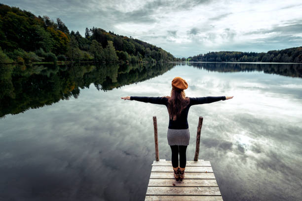 istock woman at a dock at a beautiful lake in austria 1179636509